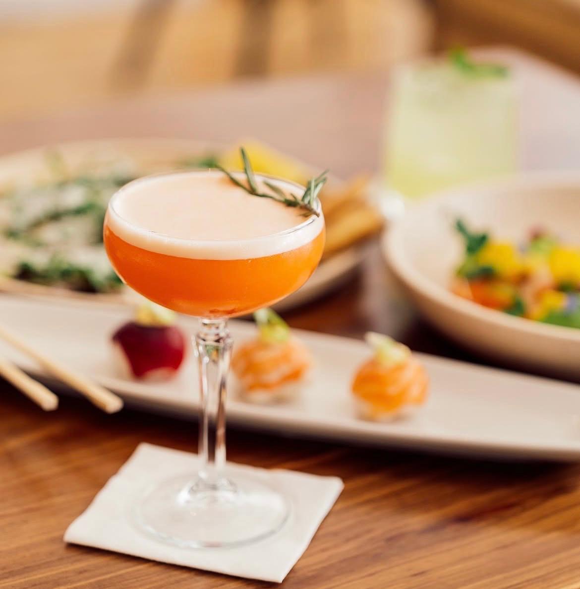 Cocktails on a bronze bar with a lively evening crowd